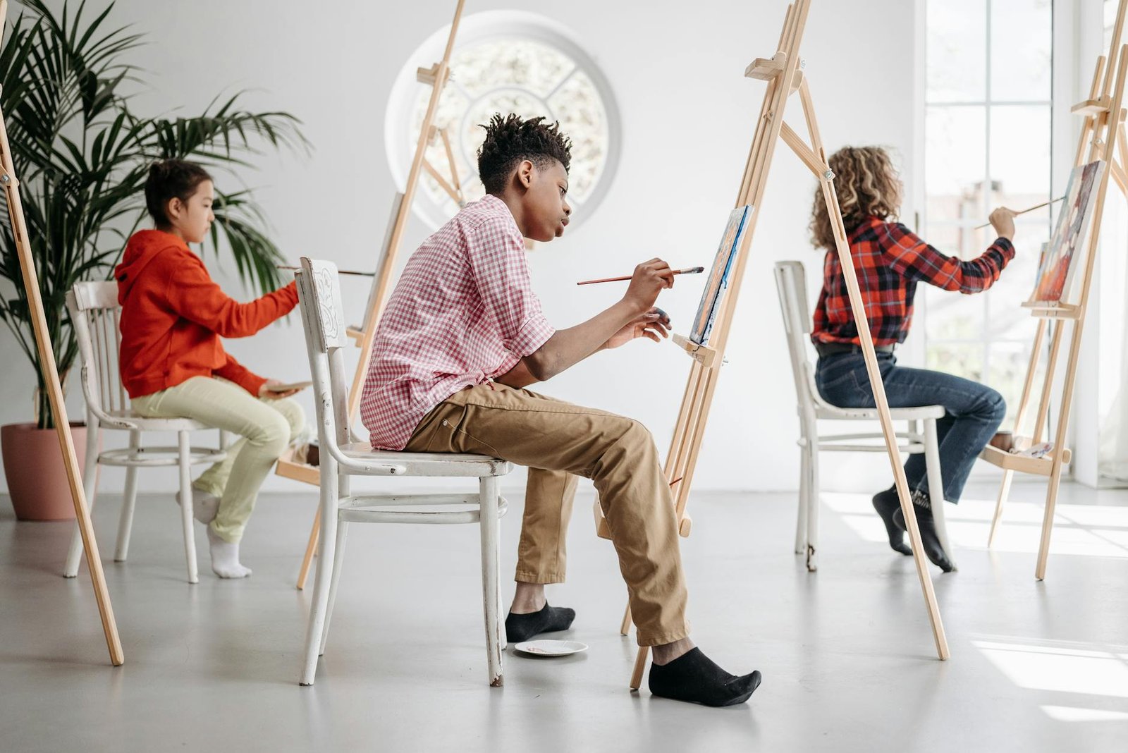 Children painting on easels during an art class