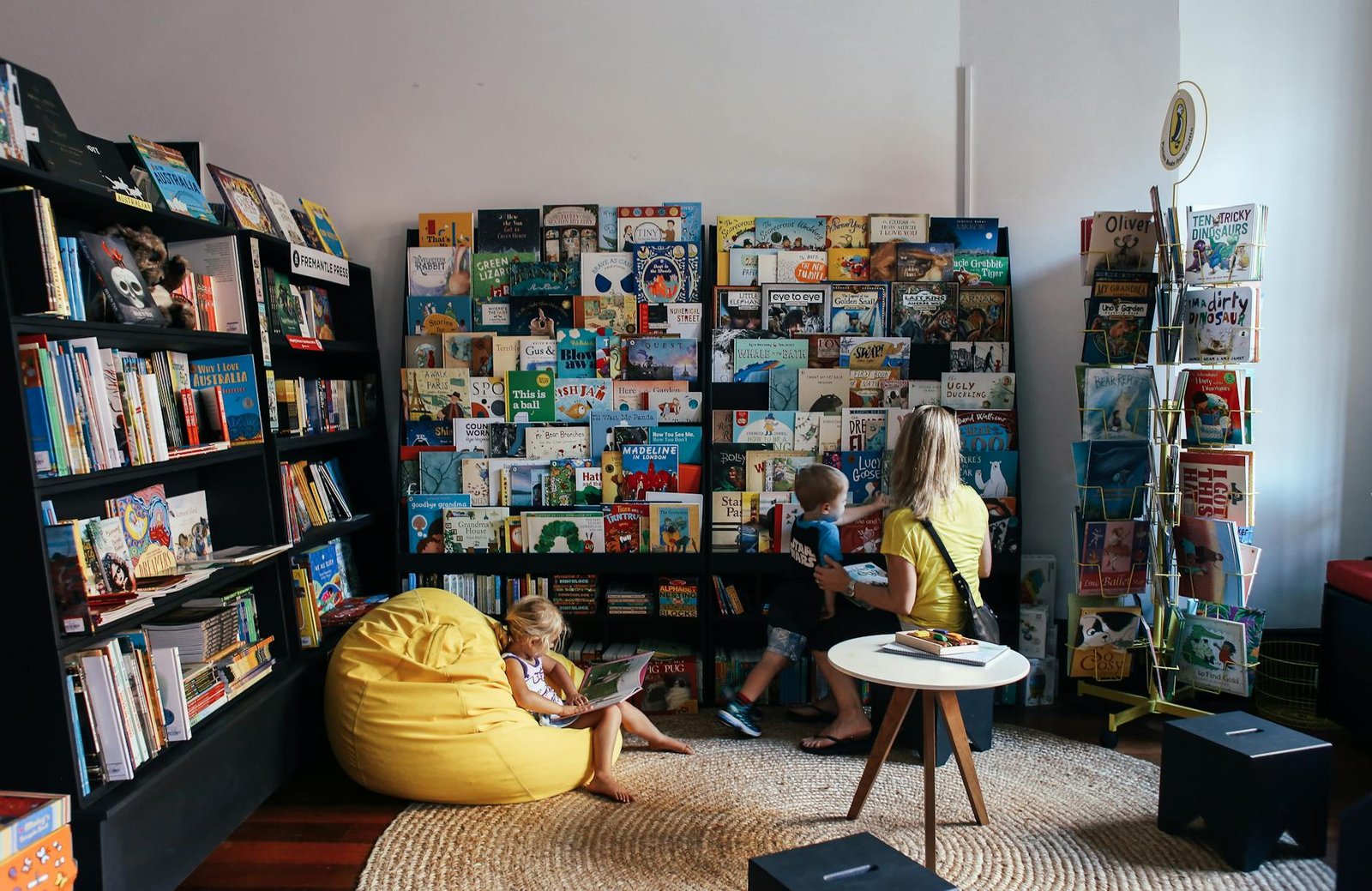 Children and parent reading books in a colourful library